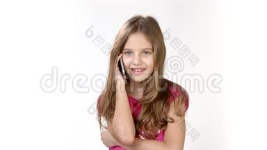 在一个小女孩的电话里情绪化的谈话。 一个小女孩穿着一件白色的亮粉色连衣裙在打电话